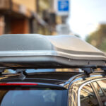 Auto s naloženým strešným boxom jazdiace po diaľnici.