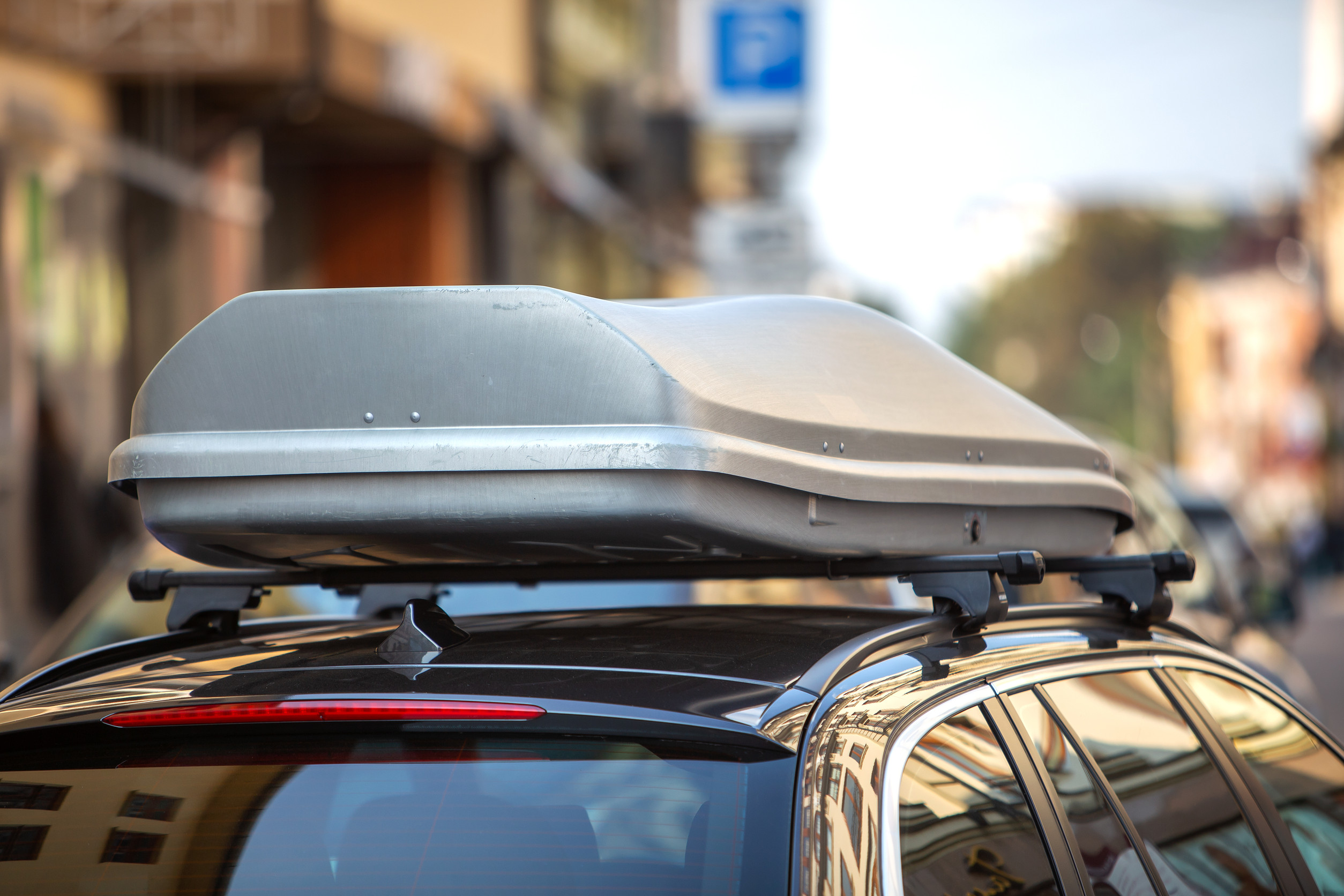 Auto s naloženým strešným boxom jazdiace po diaľnici.